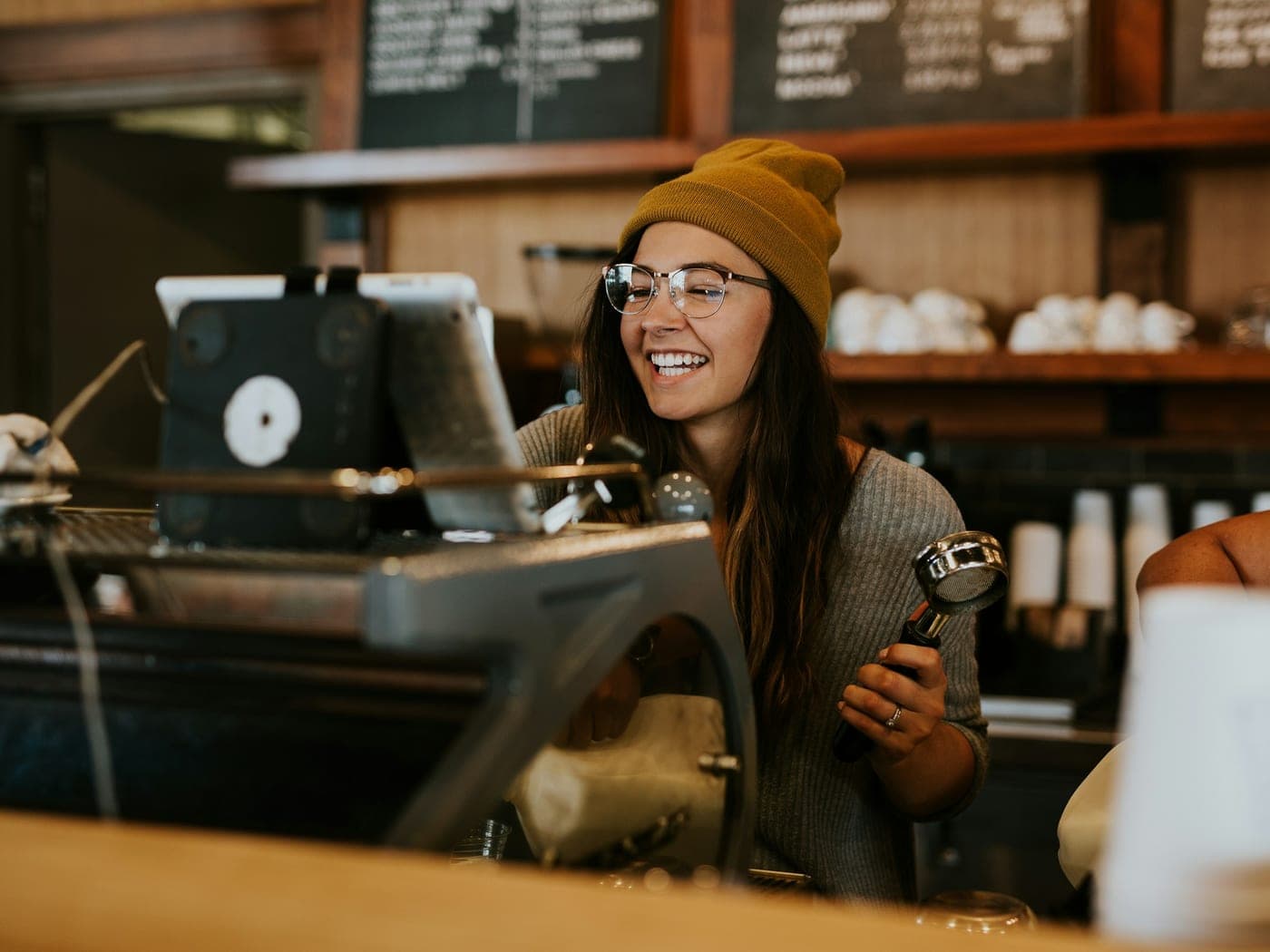 Atendente sorrindo no balcão de um café